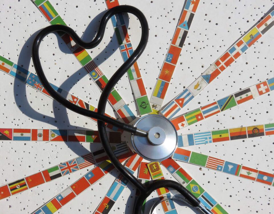 stethoscope in the middle of flags from around the world