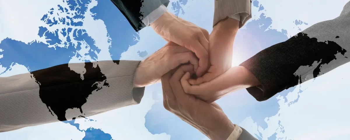 multiple hands joined together over the globe